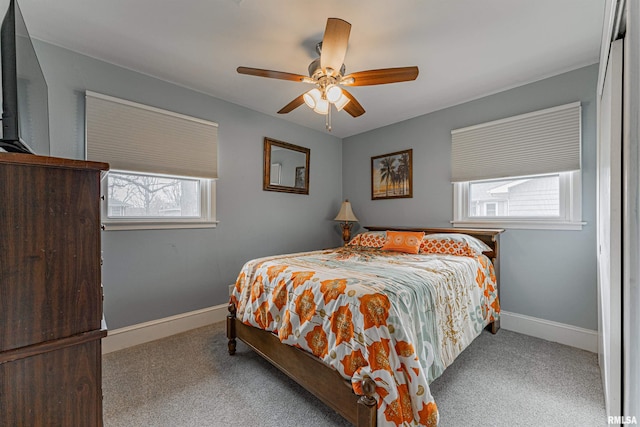 carpeted bedroom with ceiling fan and baseboards