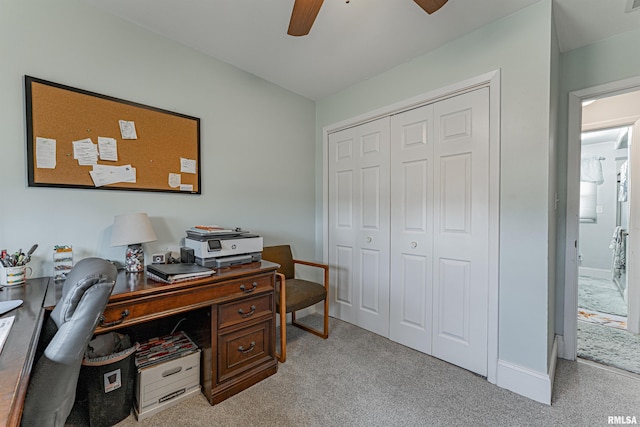 office space featuring light carpet and a ceiling fan