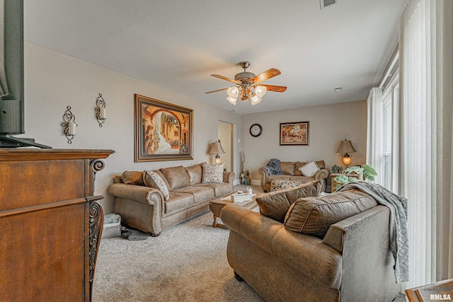 living area with a ceiling fan, light carpet, and visible vents