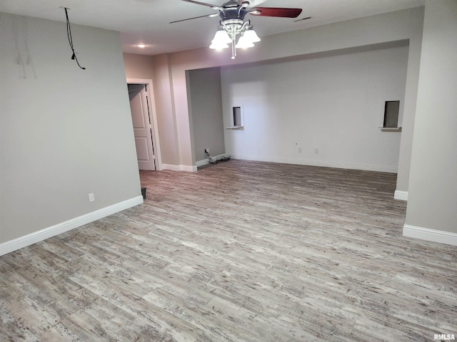 unfurnished living room with baseboards, ceiling fan, wood finished floors, and visible vents