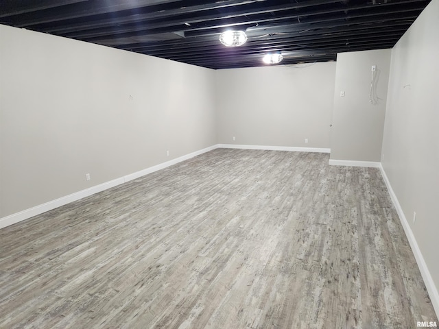 finished below grade area featuring baseboards and wood finished floors