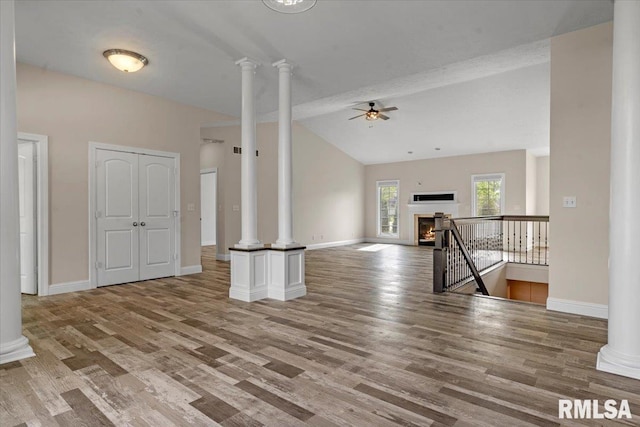 unfurnished living room with ceiling fan, decorative columns, and wood finished floors