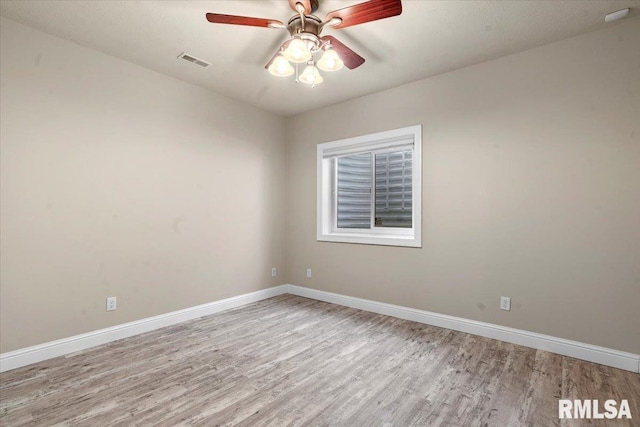 unfurnished room with baseboards, wood finished floors, and visible vents