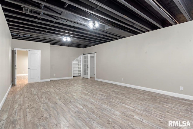 finished below grade area featuring baseboards and wood finished floors
