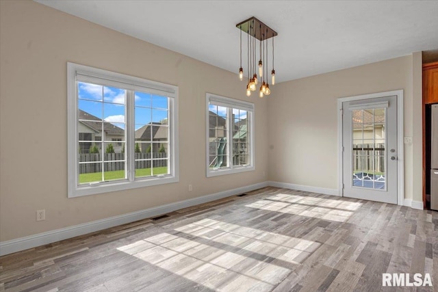 empty room with baseboards, light wood-style flooring, and visible vents