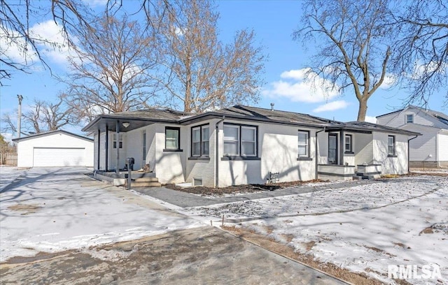 view of front of property featuring an outbuilding, brick siding, and a detached garage