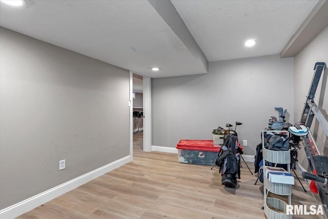 interior space featuring recessed lighting, light wood-style flooring, baseboards, and a textured ceiling