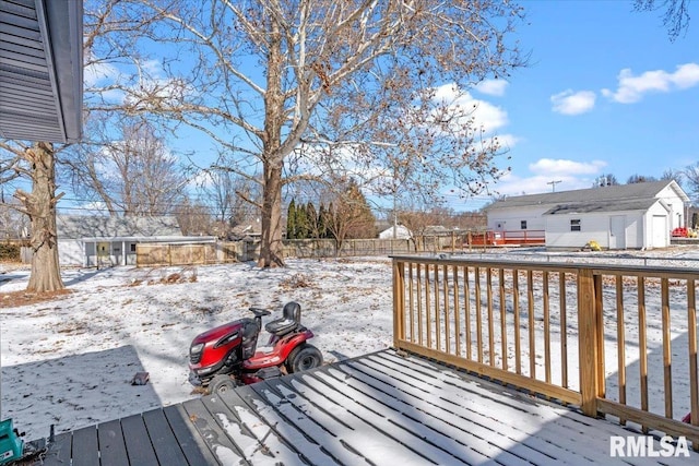 snow covered deck featuring fence