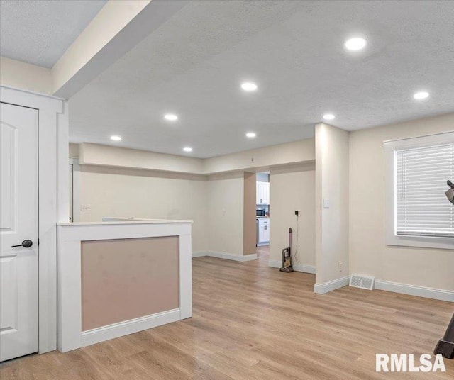 interior space featuring light wood finished floors, recessed lighting, light countertops, visible vents, and baseboards