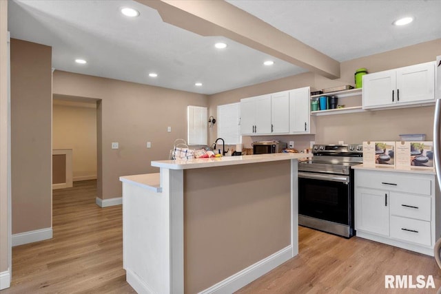 kitchen with light countertops, light wood-style flooring, electric range, white cabinetry, and an island with sink