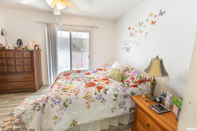 bedroom with access to exterior, light wood-type flooring, and a ceiling fan