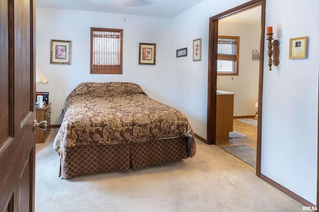 bedroom with light carpet and baseboards