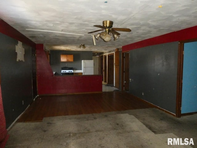 unfurnished living room featuring baseboards, a ceiling fan, and wood finished floors