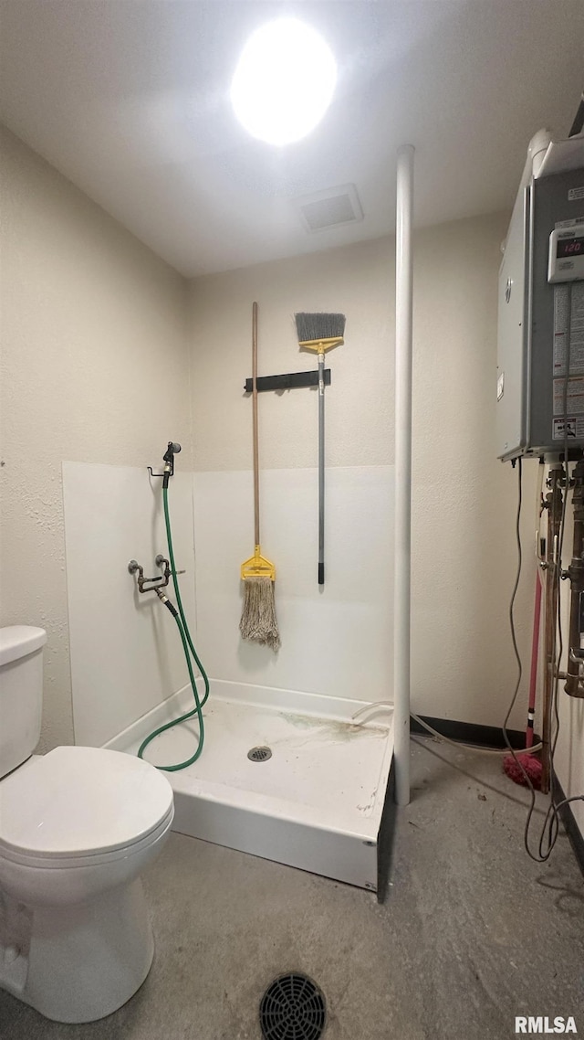 bathroom with toilet, a shower stall, and concrete flooring