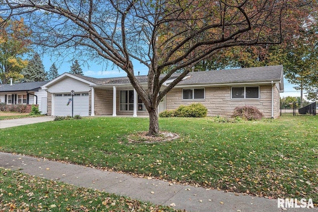 ranch-style home with a front yard, stone siding, an attached garage, and concrete driveway