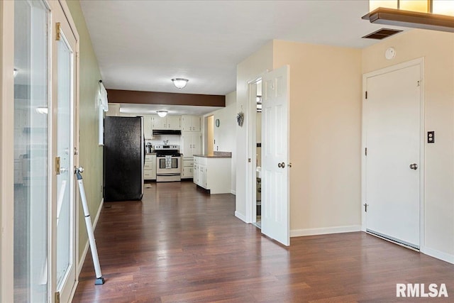 kitchen with appliances with stainless steel finishes, white cabinetry, under cabinet range hood, and dark wood-style floors