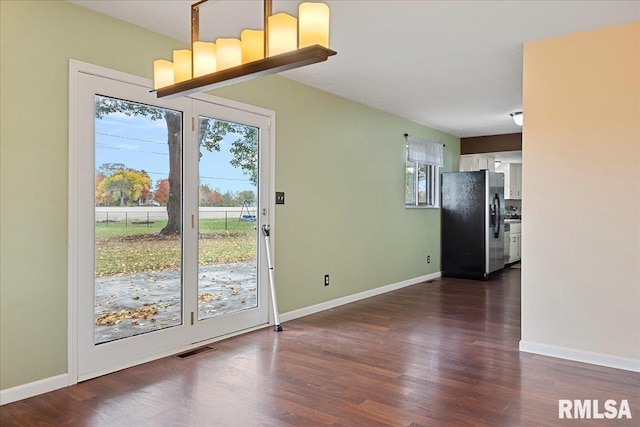 doorway featuring dark wood-style floors, baseboards, and visible vents