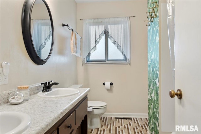 full bathroom featuring toilet, a sink, visible vents, baseboards, and double vanity