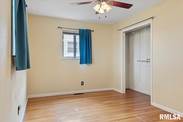 unfurnished bedroom featuring light wood finished floors, baseboards, visible vents, a ceiling fan, and a closet