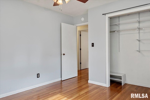 unfurnished bedroom featuring ceiling fan, a closet, wood finished floors, and baseboards