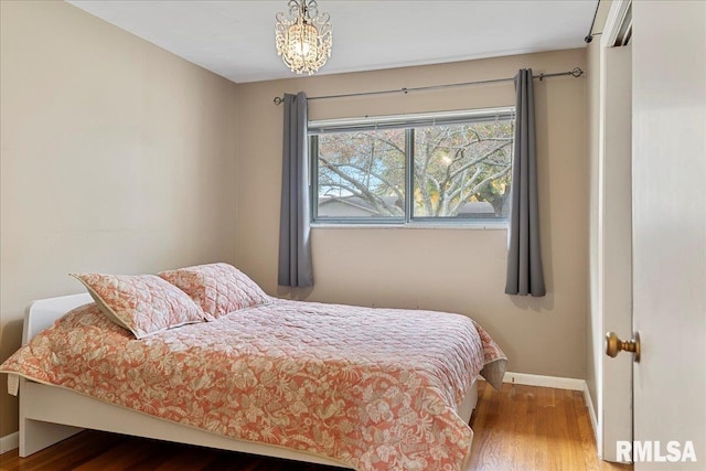 bedroom with wood finished floors and baseboards