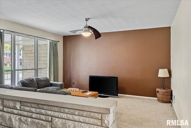 carpeted living area featuring a ceiling fan, a textured ceiling, and baseboards