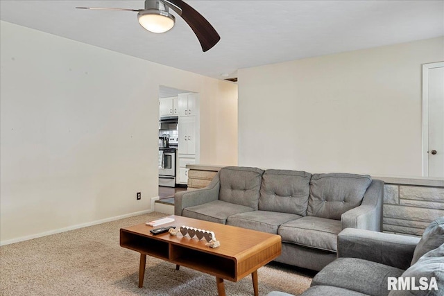 living area featuring a ceiling fan, light carpet, and baseboards