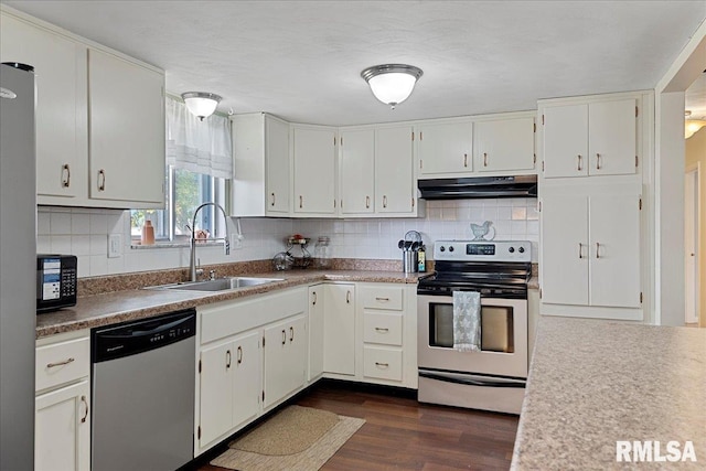 kitchen with under cabinet range hood, stainless steel appliances, dark wood-type flooring, a sink, and white cabinetry