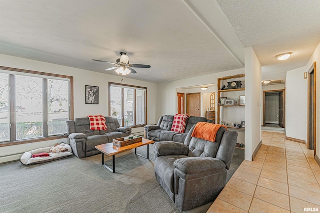 living room featuring a healthy amount of sunlight, light tile patterned floors, ceiling fan, and a textured ceiling