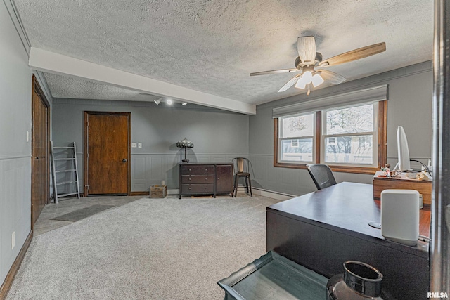 office space featuring carpet, a wainscoted wall, ceiling fan, and a textured ceiling