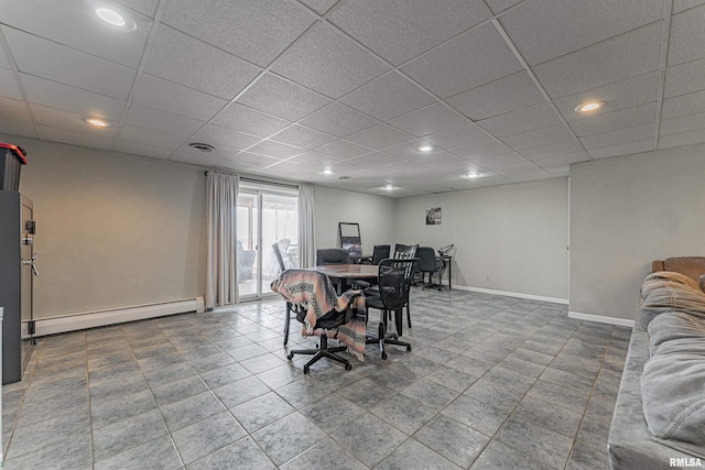 dining room with a baseboard heating unit, recessed lighting, a drop ceiling, and baseboards