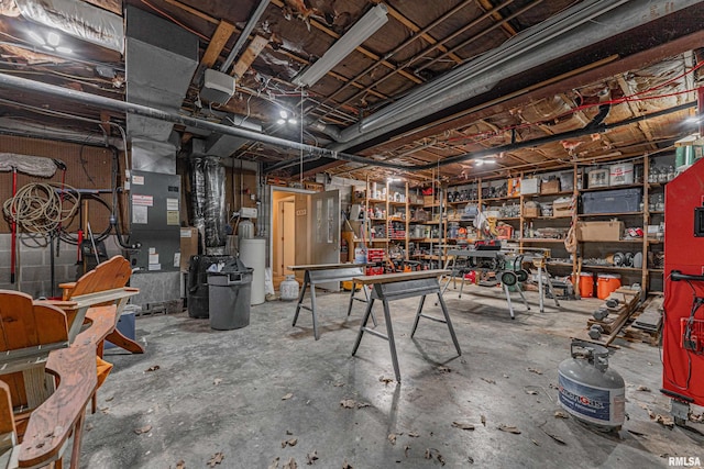 unfinished basement featuring water heater and a workshop area