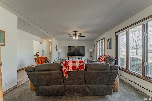 carpeted living room featuring a baseboard heating unit, tile patterned flooring, a ceiling fan, and baseboards