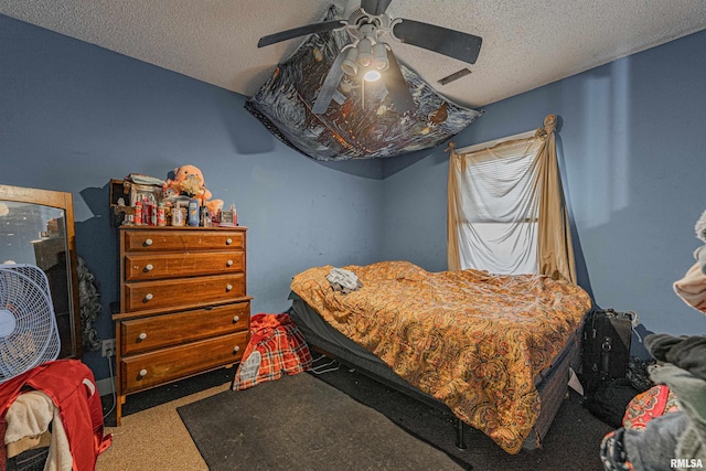 bedroom with a ceiling fan, carpet, visible vents, and a textured ceiling