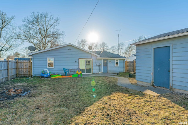 back of house featuring a fenced backyard and a yard