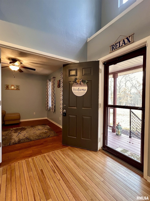 entrance foyer featuring light wood-type flooring, baseboards, and a ceiling fan