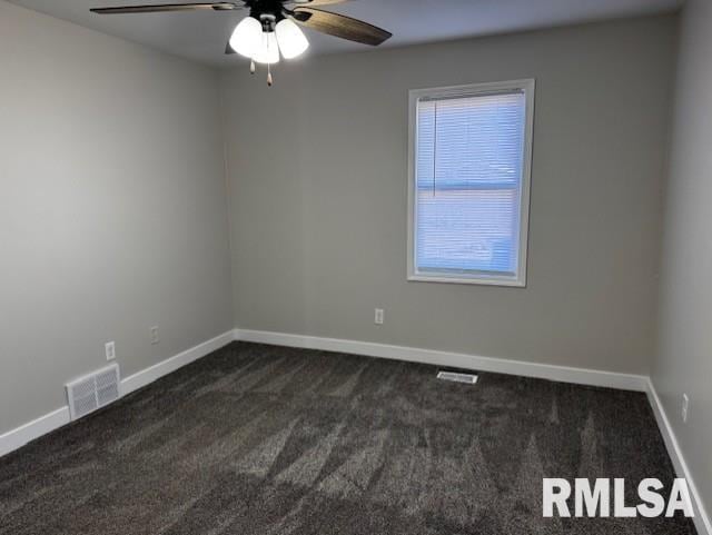 empty room with dark colored carpet, visible vents, ceiling fan, and baseboards