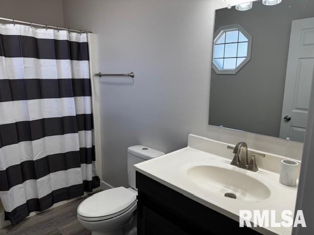 full bathroom featuring wood finished floors, a shower with shower curtain, vanity, and toilet