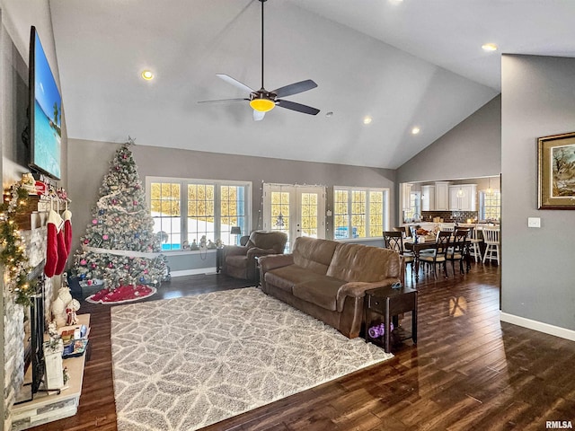 living area with high vaulted ceiling, dark wood-style flooring, plenty of natural light, and baseboards