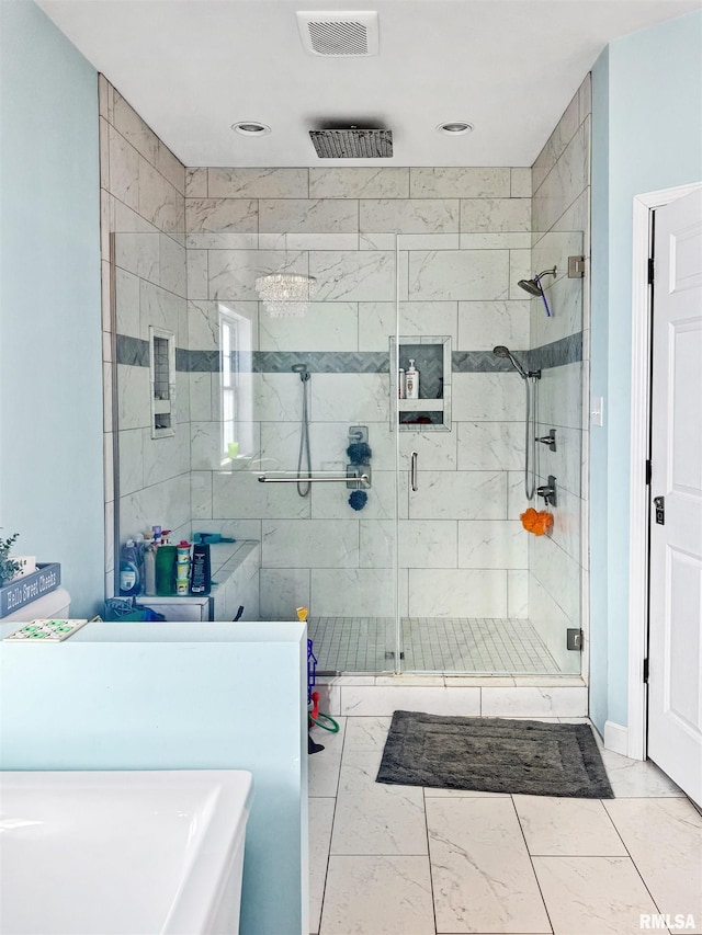 bathroom featuring marble finish floor, a stall shower, and visible vents