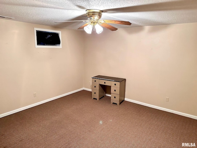 below grade area featuring baseboards, visible vents, ceiling fan, a textured ceiling, and dark carpet