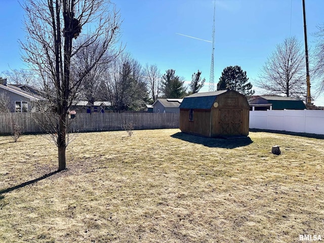 view of yard with a storage shed, an outdoor structure, and a fenced backyard