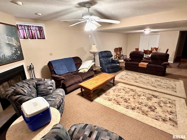 carpeted living area featuring a fireplace, a ceiling fan, and a textured ceiling