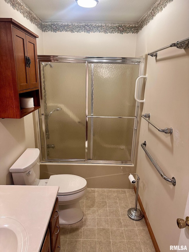 full bathroom with toilet, combined bath / shower with glass door, vanity, baseboards, and tile patterned floors