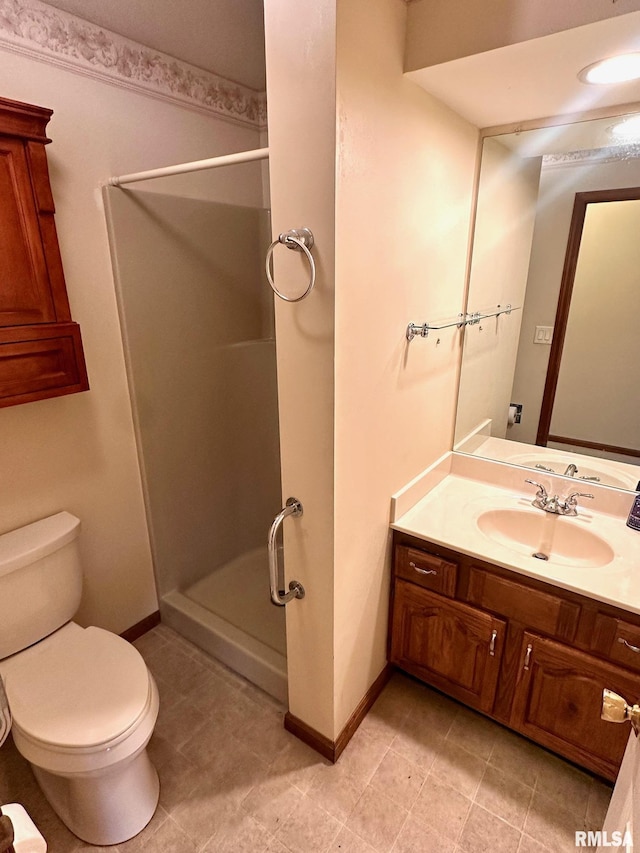 full bathroom featuring toilet, a shower stall, vanity, and baseboards