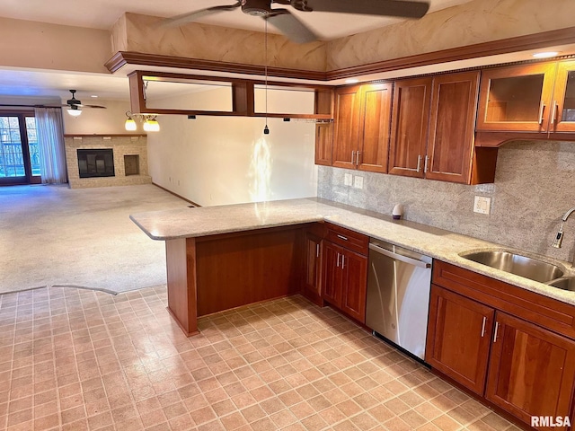 kitchen featuring dishwasher, ceiling fan, brown cabinets, light stone countertops, and a sink