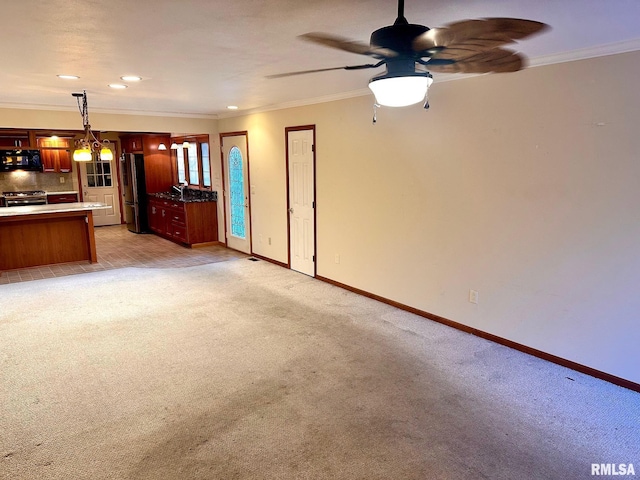 unfurnished living room with baseboards, ornamental molding, a ceiling fan, and light colored carpet