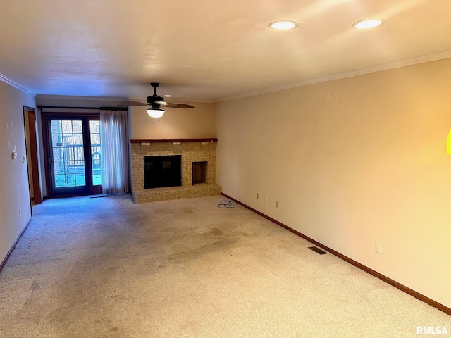 unfurnished living room with carpet floors, ornamental molding, a brick fireplace, and baseboards