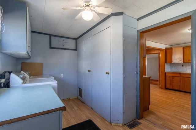 kitchen featuring visible vents, light wood-style flooring, brown cabinets, light countertops, and washer and dryer