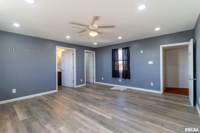 unfurnished bedroom featuring recessed lighting, wood finished floors, and baseboards